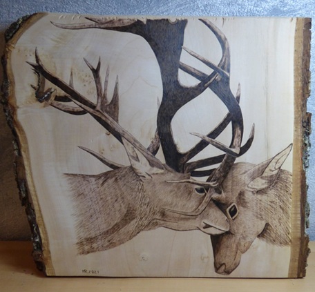 Œuvre de pyrogravure présentée dans un stand, offrant des détails visuels intéressants pour les visiteurs