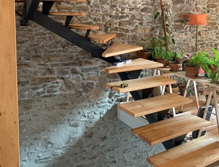 Artisan métallier-ferronnier exposant des pièces en métal dans un stand accueillant